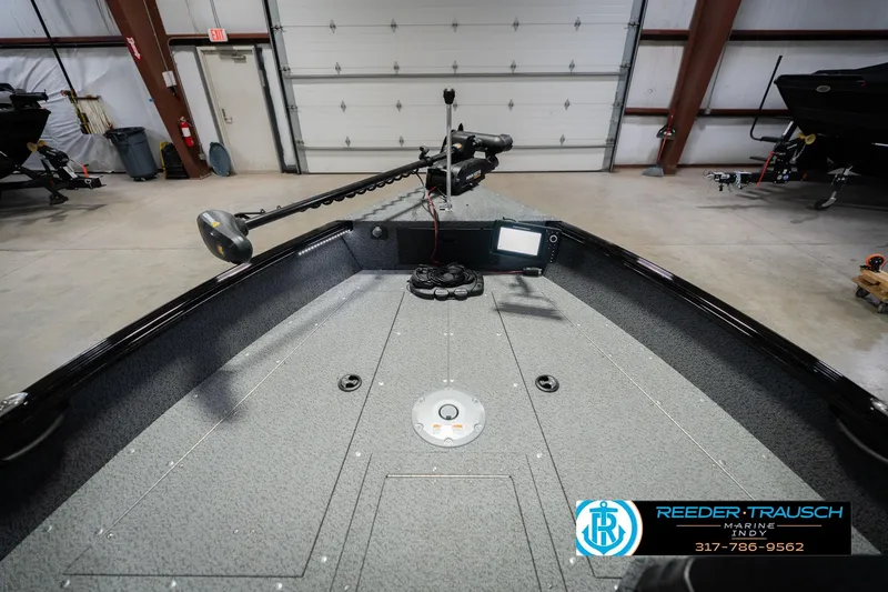 Slide: The Image of 2026 Lund 1700 Explorer SS boat interior with trolling motor and control panel in a showroom. - 17