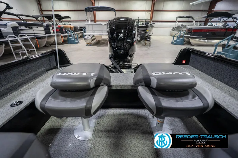 Slide: The Image of 2026 Lund 1700 Explorer SS boat interior with dual seats in a showroom. - 21