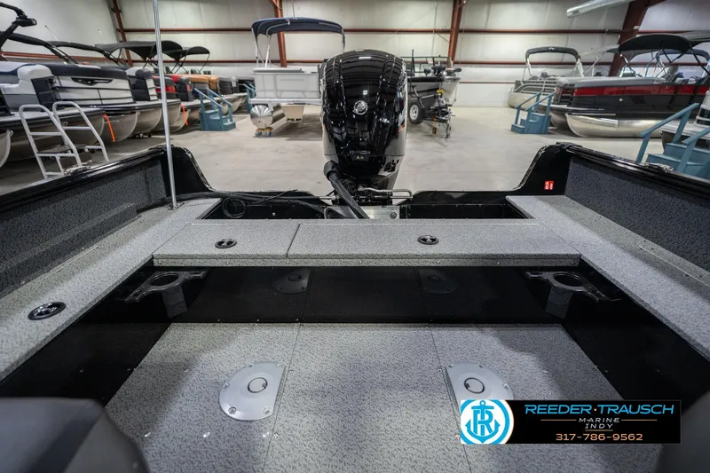 Slide: The Image of 2026 Lund 1700 Explorer SS boat interior in showroom, featuring spacious deck and modern design. - 22