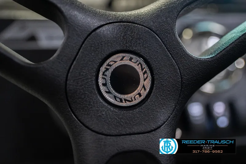 Slide: The Image of Steering wheel of 2026 Lund 1700 Explorer SS boat, featuring logo and textured grip. - 32