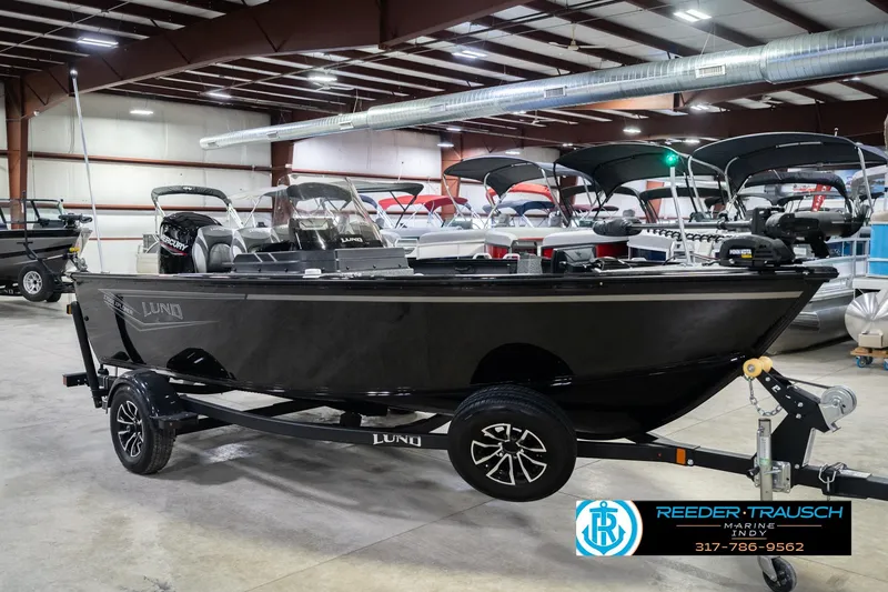 Slide: The Image of 2026 Lund 1700 Explorer SS boat in showroom, black exterior, on trailer. - 5
