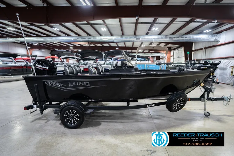Slide: The Image of 2026 Lund 1700 Explorer SS boat in showroom, featuring sleek design and Mercury engine. - 6