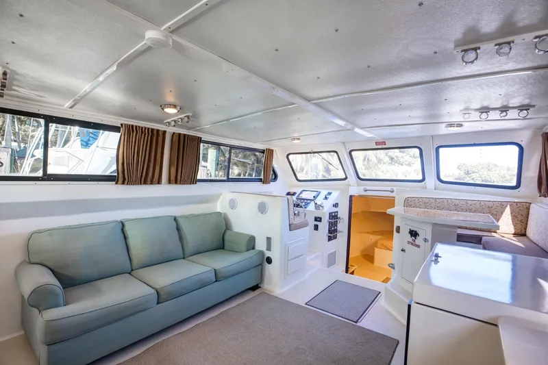 Slide: The Image of Interior of 2014 Chesapeake 46 Trawler with sofa, helm, and dining area. - 10