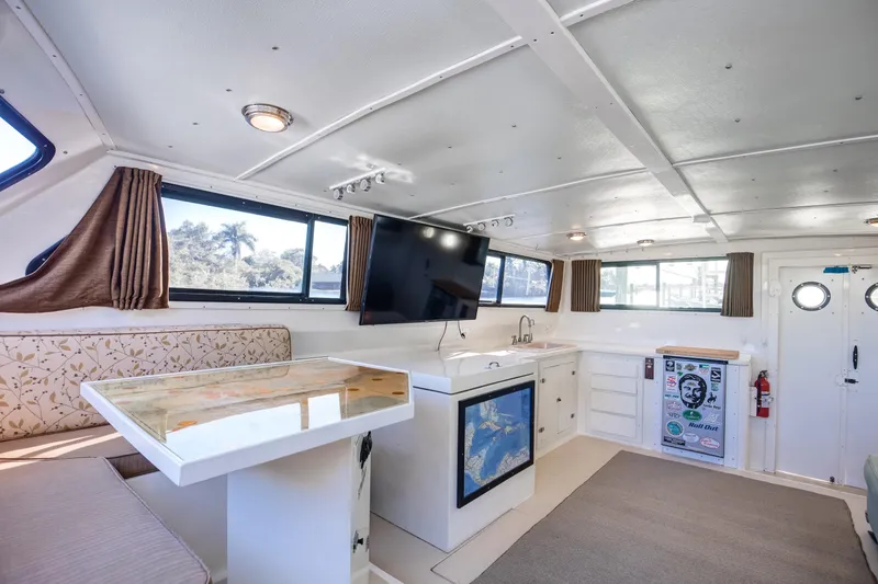 Slide: The Image of Interior of 2014 Chesapeake 46 Trawler with modern kitchen, seating, and large windows. - 14