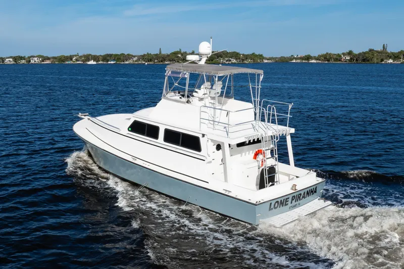 Slide: The Image of 2014 Chesapeake 46 Trawler cruising on open water, named "Lone Piranha." - 2