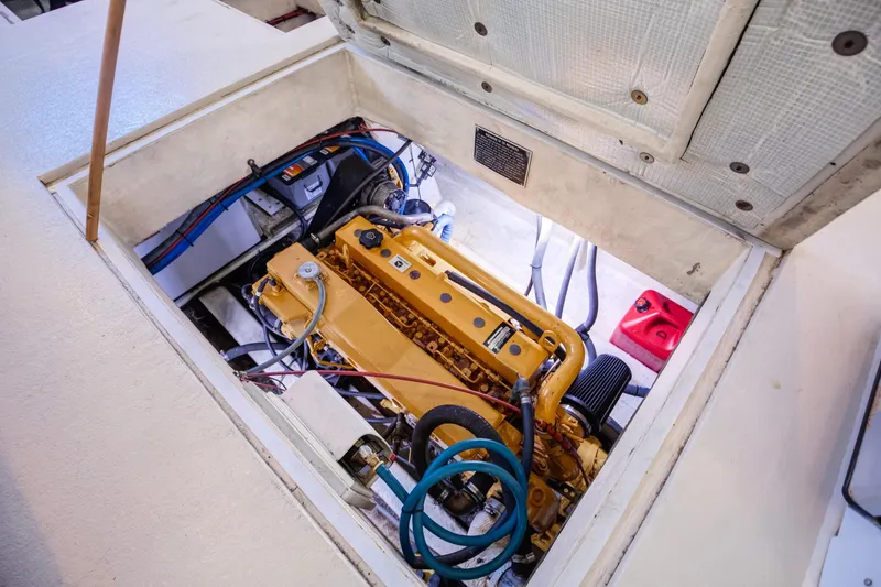 Slide: The Image of Engine compartment of 2014 Chesapeake 46 Trawler, showcasing yellow engine and surrounding components. - 31