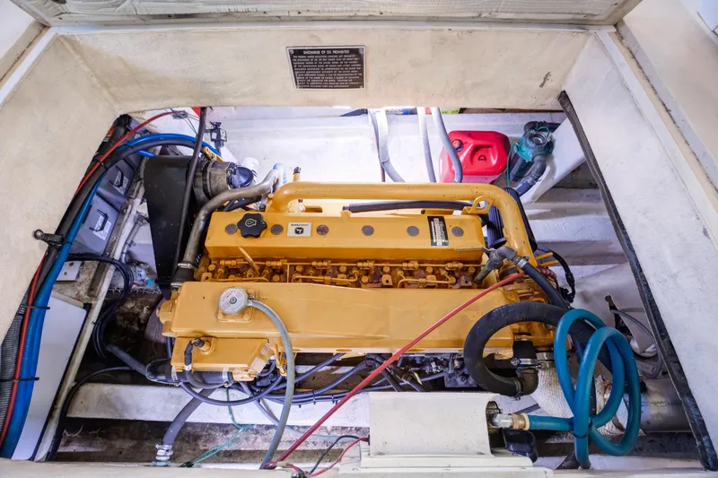 Slide: The Image of Engine compartment of 2014 Chesapeake 46 Trawler, showcasing yellow marine engine and components. - 32