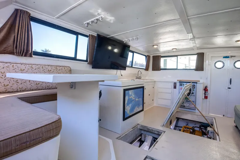 Slide: The Image of Interior of 2014 Chesapeake 46 Trawler with seating, table, and open engine hatch. - 9