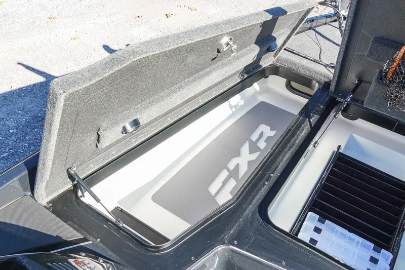 Slide: The Image of 2021 Skeeter FXR20 Apex boat storage compartment with open lid and organized interior. - 23