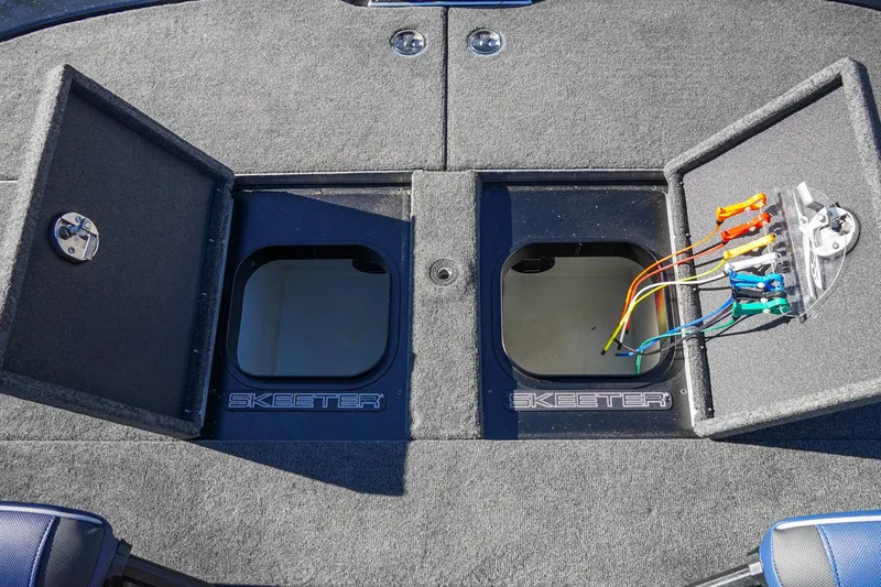 Slide: The Image of 2021 Skeeter FXR20 Apex boat storage compartments with open lids and colorful wiring. - 27