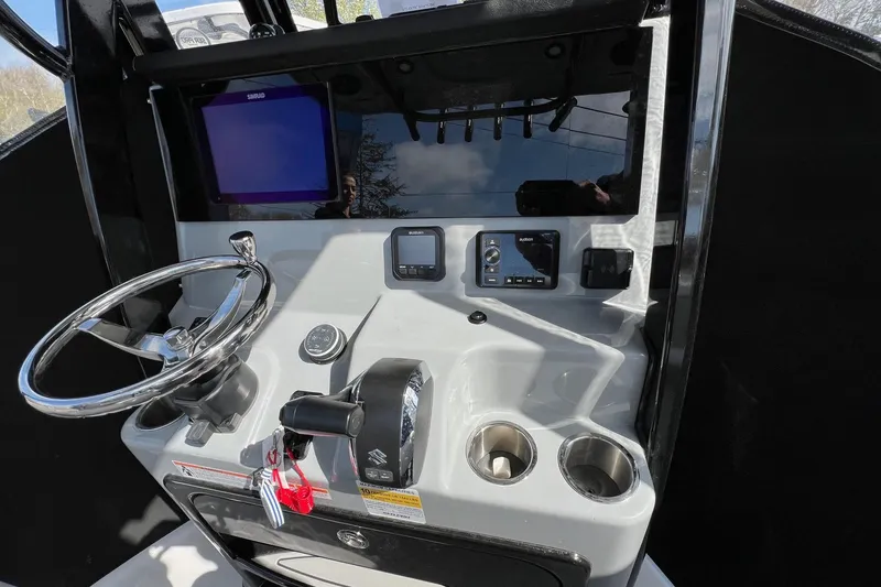 Slide: The Image of Steering console of 2026 Sea Pro 245FLX Sandbar boat with modern controls and display. - 12
