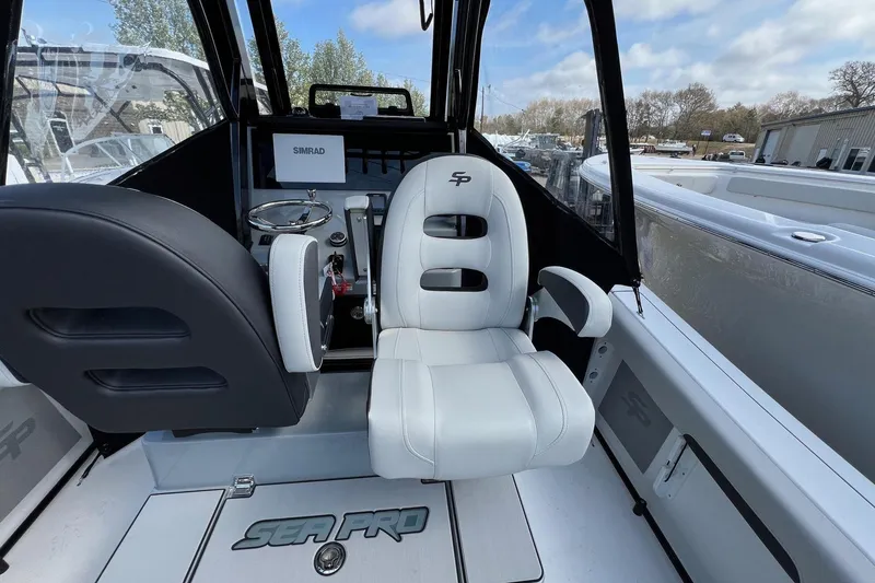 Slide: The Image of 2026 Sea Pro 245FLX Sandbar boat interior with white seating and steering console. - 17