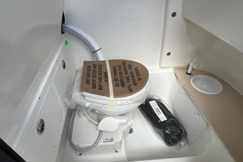 Slide: The Image of Interior of 2026 Sea Pro 245FLX Sandbar boat featuring a compact bathroom setup. - 26
