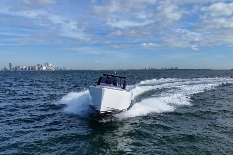 Slide: The Image of 2013 Fjord 40' Open boat cruising on ocean with city skyline in background. - 10