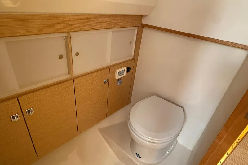 Slide: The Image of Compact bathroom in 2013 Fjord 40' Open yacht with wooden cabinetry and modern toilet. - 101