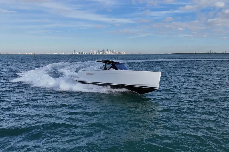 Slide: The Image of 2013 Fjord 40' Open yacht cruising on open water with city skyline in background. - 17
