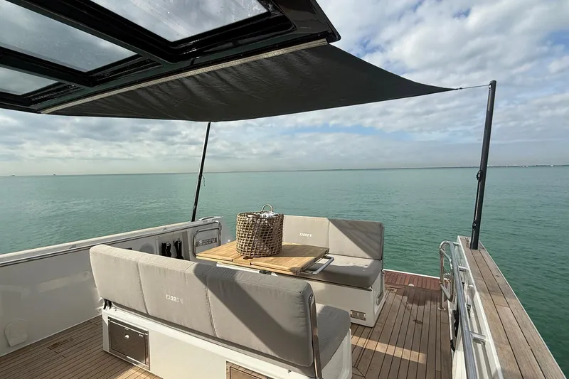 Slide: The Image of 2013 Fjord 40' Open yacht deck with seating, table, and ocean view. - 45