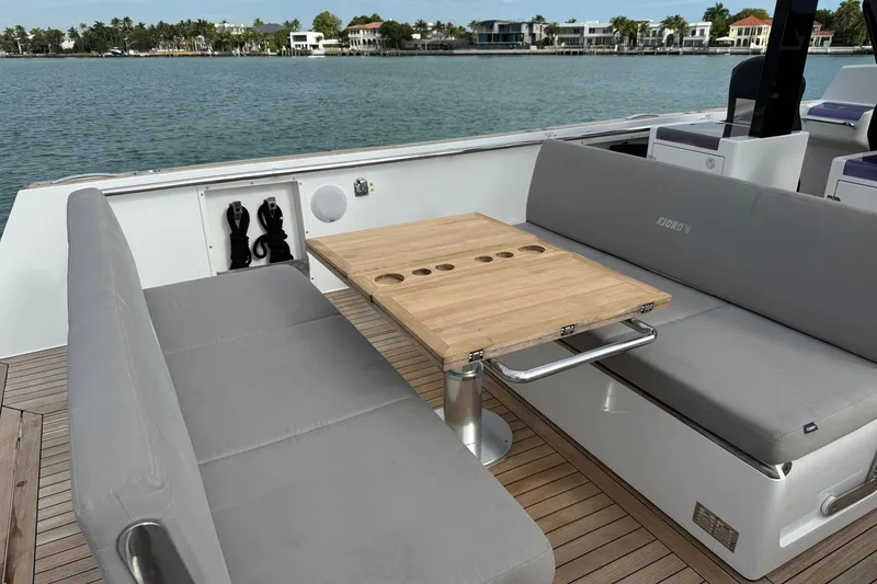 Slide: The Image of Luxurious seating area on 2013 Fjord 40' Open yacht with wooden table and waterfront view. - 85