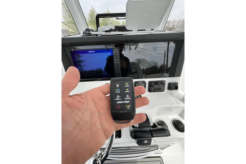 Slide: The Image of Hand holding remote in 2026 Sea Pro 262 Offshore boat cockpit. - 14