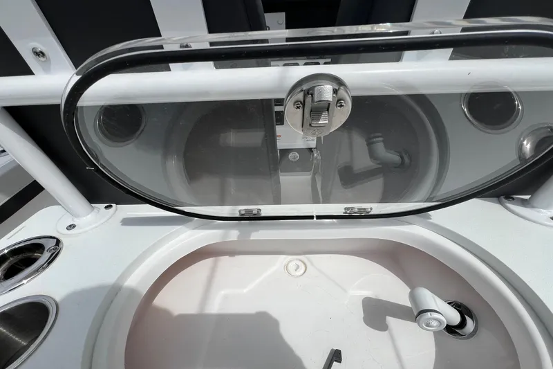 Slide: The Image of Livewell compartment on a 2026 Sea Pro 262 Offshore boat, featuring a transparent lid and faucet. - 37