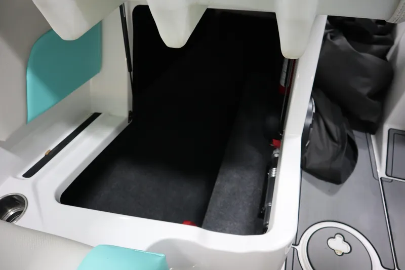 Slide: The Image of 2020 MasterCraft NXT22 boat interior storage compartment with teal accents. - 14