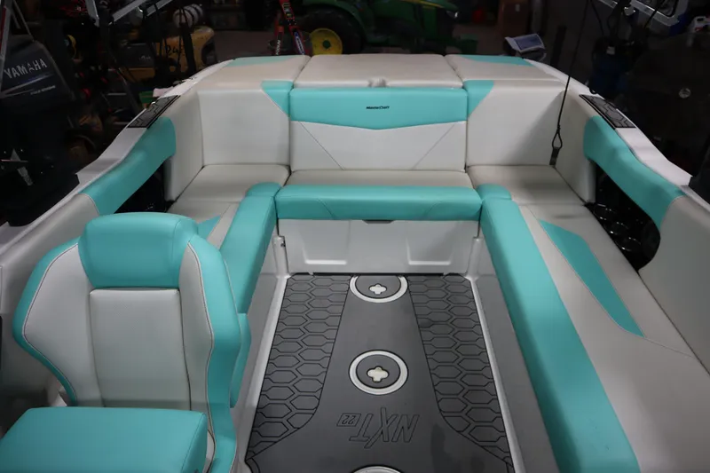 Slide: The Image of 2020 MasterCraft NXT22 boat interior with teal and white seating, hexagonal floor design. - 15