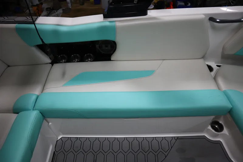 Slide: The Image of 2020 MasterCraft NXT22 boat interior with teal and white seating, featuring cup holders. - 16