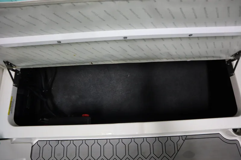 Slide: The Image of Open storage compartment in 2020 MasterCraft NXT22 boat, featuring hexagonal floor pattern. - 17