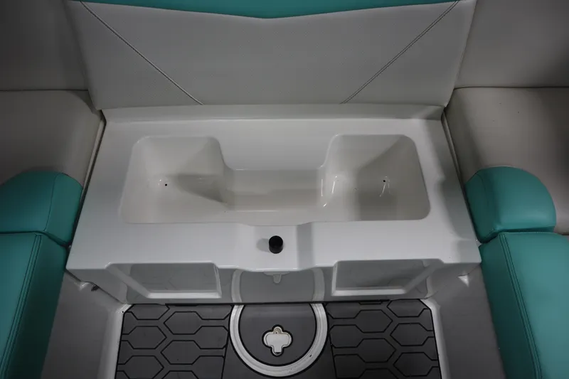 Slide: The Image of 2020 MasterCraft NXT22 boat interior with teal and white seating and storage compartment. - 19