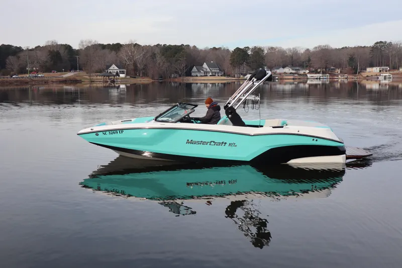 Slide: The Image of 2020 MasterCraft NXT22 boat on a calm lake with scenic background. - 2