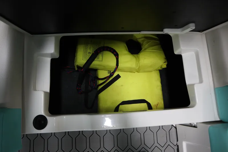 Slide: The Image of Storage compartment in a 2020 MasterCraft NXT22 boat with life jackets and rope. - 21