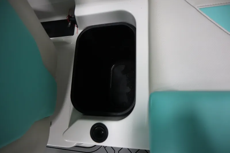 Slide: The Image of Interior storage compartment of 2020 MasterCraft NXT22 boat with teal and white seating. - 22