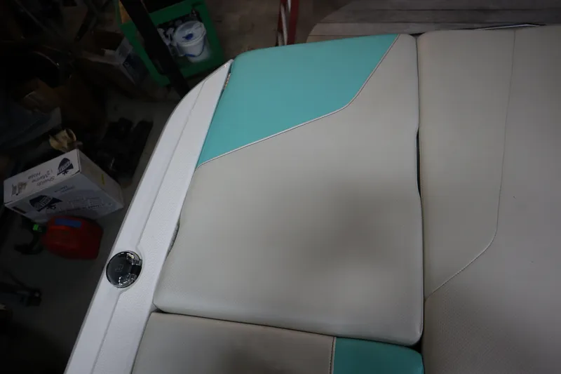 Slide: The Image of 2020 MasterCraft NXT22 boat seat with teal and beige upholstery in a garage setting. - 25
