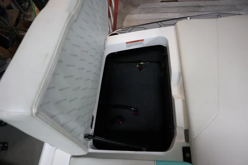Slide: The Image of Open storage compartment in 2020 MasterCraft NXT22 boat with cushioned lid. - 26