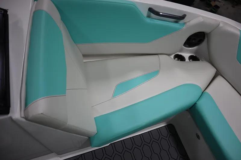 Slide: The Image of 2020 MasterCraft NXT22 boat interior with teal and white seating, cup holders, and handle. - 5