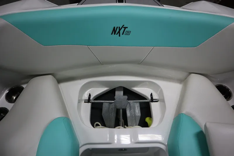 Slide: The Image of 2020 MasterCraft NXT22 boat interior with teal and white seating, anchor storage. - 7