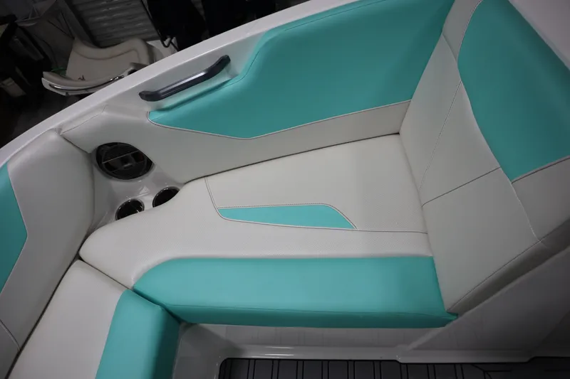 Slide: The Image of 2020 MasterCraft NXT22 boat interior with teal and white seating, cup holders, and speaker. - 8