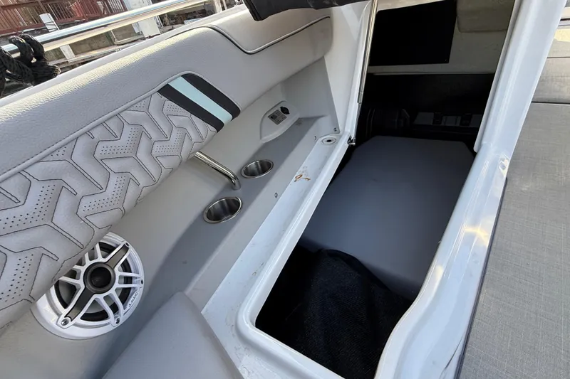 Slide: The Image of 2024 Regal LX9 boat interior with storage compartment, cup holders, and speaker. - 18