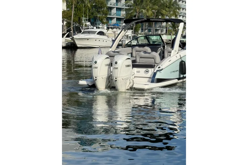 Slide: The Image of 2024 Regal LX9 boat with dual Yamaha 200 engines docked in marina. - 26