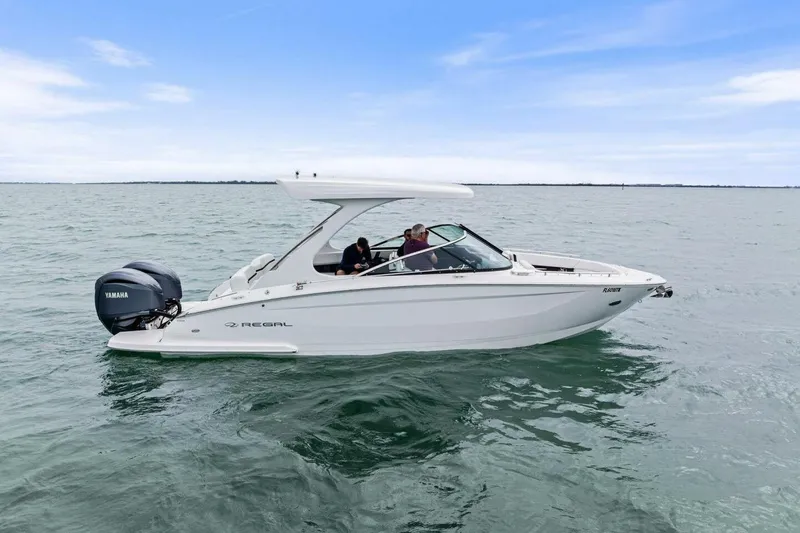 Slide: The Image of 2023 Regal 29 OBX boat cruising on open water with Yamaha outboard engine. - 1