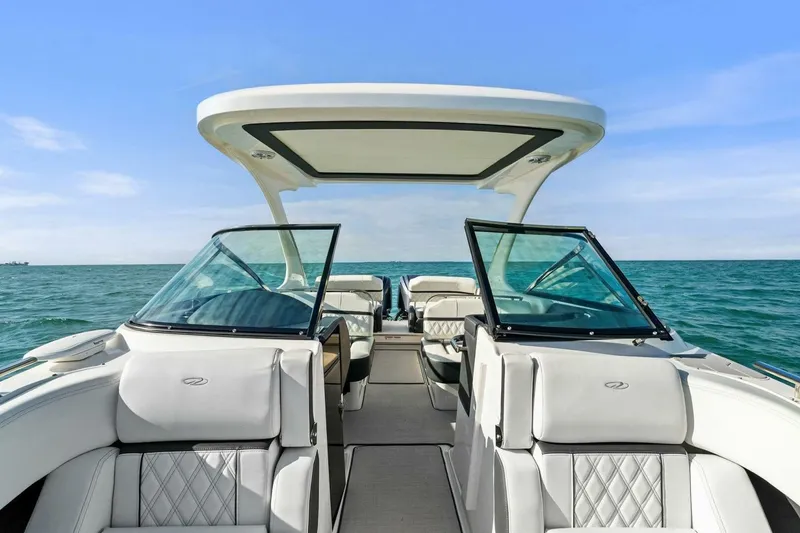 Slide: The Image of 2023 Regal 29 OBX boat interior with open seating, cruising on a clear blue sea. - 30