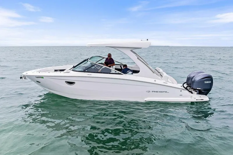 Slide: The Image of 2023 Regal 29 OBX boat cruising on open water with Yamaha outboard engine. - 32
