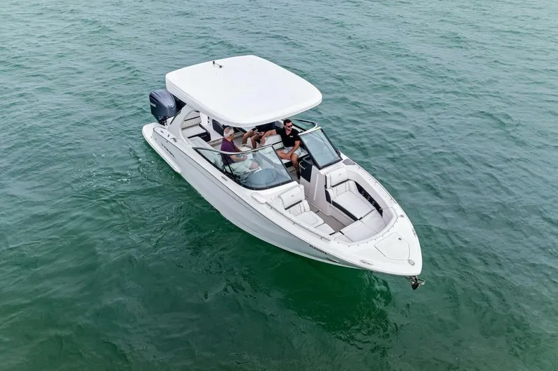 Slide: The Image of 2023 Regal 29 OBX boat cruising on clear blue water, featuring sleek design and spacious seating. - 39