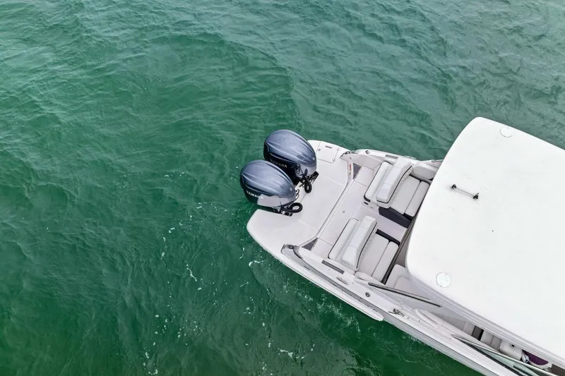 Slide: The Image of 2023 Regal 29 OBX boat with dual outboard motors on green water. - 40