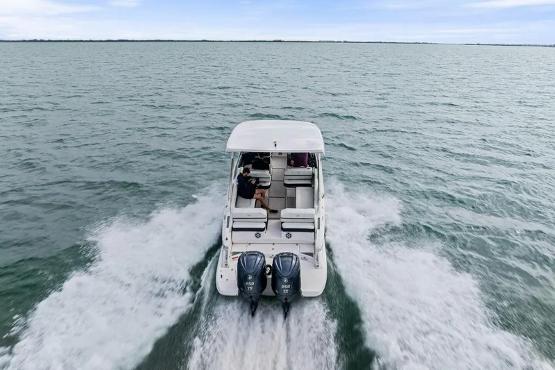 Slide: The Image of 2023 Regal 29 OBX boat cruising on open water, rear view. - 43