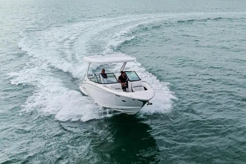 Slide: The Image of 2023 Regal 29 OBX boat cruising on open water, creating a dynamic wake. - 46