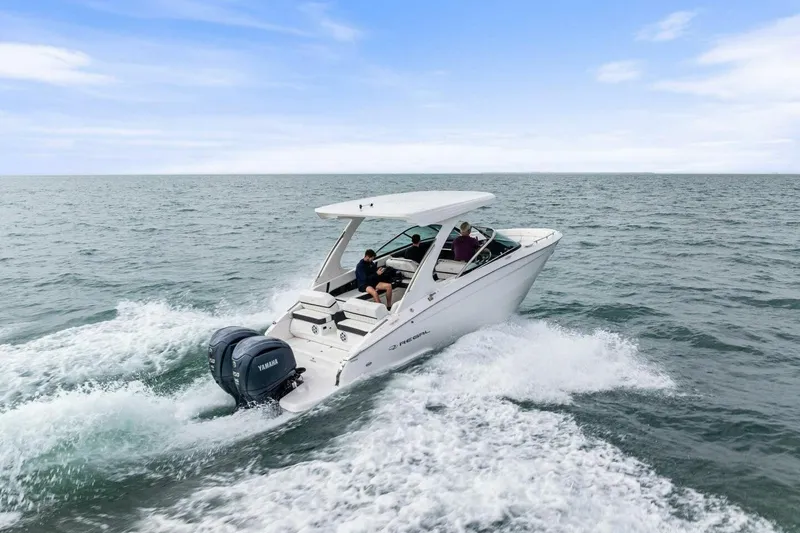 Slide: The Image of 2023 Regal 29 OBX boat cruising on open water with Yamaha engines. - 47