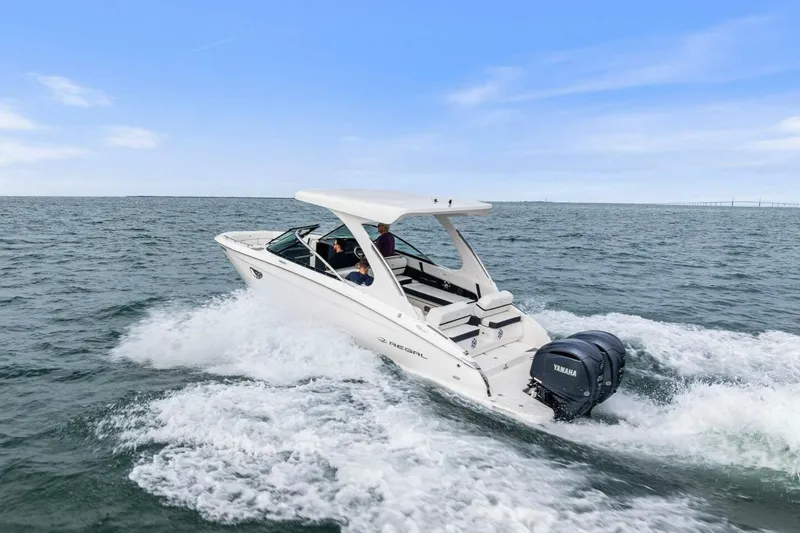 Slide: The Image of 2023 Regal 29 OBX boat cruising on open water with Yamaha engines. - 48