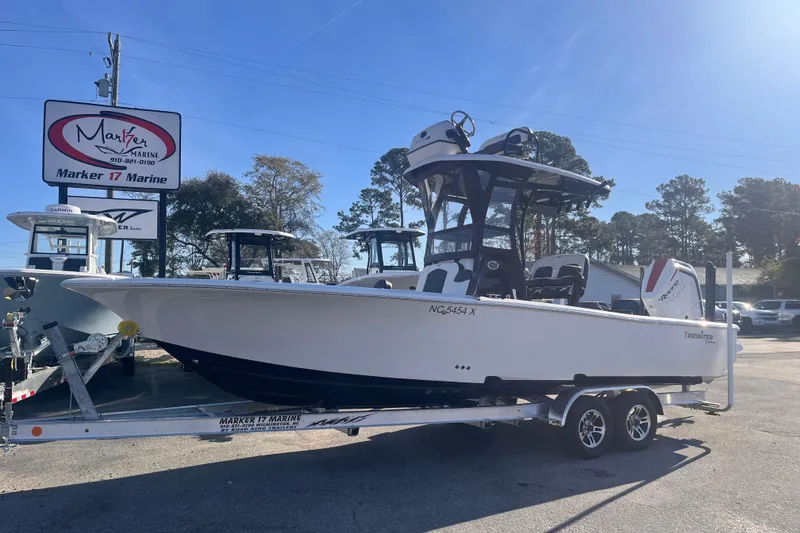 Slide: The Image of 2024 Tidewater 2500 Carolina Bay boat on trailer, featuring dual outboard engines. - 1