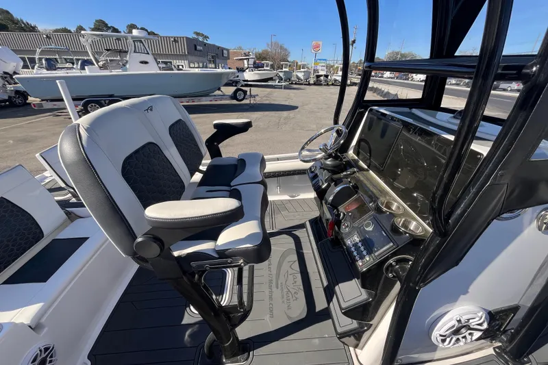 Slide: The Image of 2024 Tidewater 2500 Carolina Bay boat, docked with clear skies and surrounding vehicles. - 14